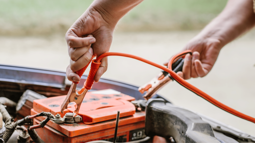 Image of jump starter being attach to car battery