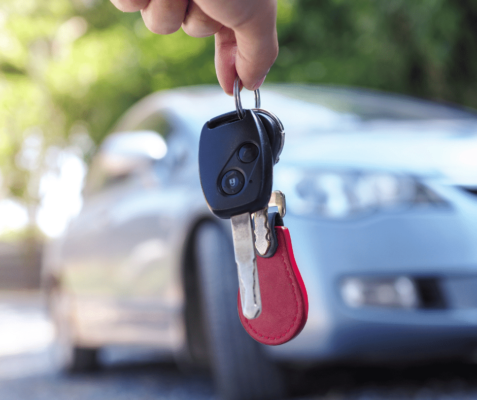 Image of car keys being held in front of sold car