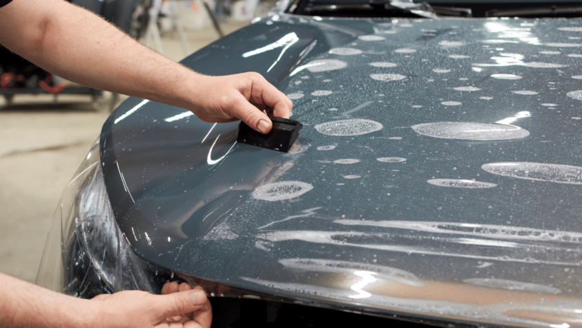 Image of car paint protection film being applied to auto body